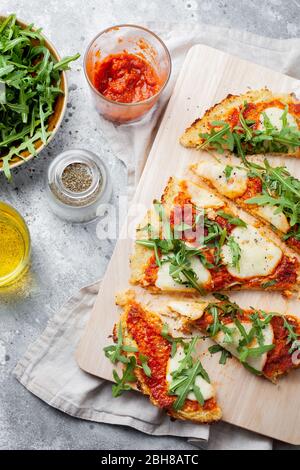 Pâte à pizza sans gluten maison à base de chou-fleur avec sauce marinara aux tomates, fromage mozzarella pour une alimentation à faible teneur en carb et en céto.vue du dessus Banque D'Images