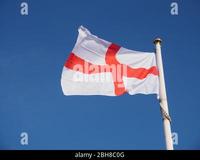 Drapeau de St George volant contre un ciel bleu d'été glorieux, Angleterre, Royaume-Uni. Banque D'Images