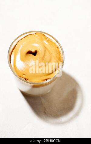 Café Dalgona crémeux à la mode et fouetté sur fond blanc.espresso à latte à boire coréen avec mousse de café instantané Banque D'Images