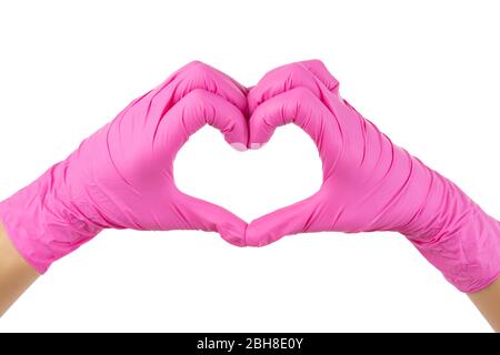 Mains féminines en gants roses jetables pour une forme de coeur isolée sur blanc. Banque D'Images