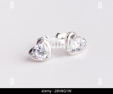 Une paire de superbes boucles d'oreilles en argent 925 en forme de coeur décorées de diamant isolé sur fond blanc Banque D'Images