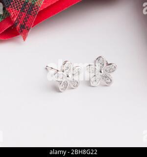Une paire de superbes boucles d'oreilles en argent 925 en forme de fleur décorées de zircone cubique isolé sur fond blanc Banque D'Images