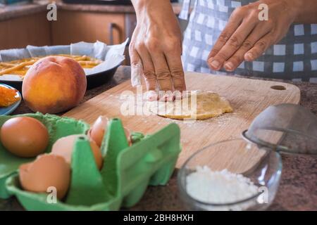 gros plan sur les mains de la femme préparant un gâteau avec des ingrédients frais crus naturels comme les pâtes farina pêche et oeufs et l'eau pour une nourriture saine mais savoureuse pour les parents et les amis à la maison - travailler dans le concept de cuisine Banque D'Images