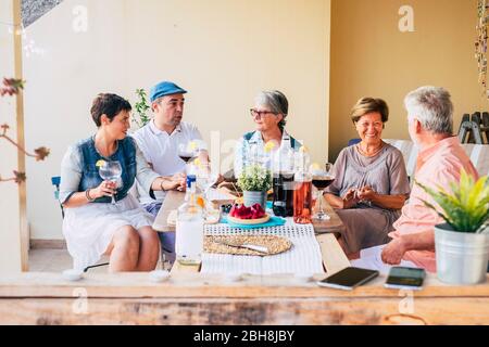 Groupe de diversité mixte âges assis à la table ayant déjeuner ensemble dans l'amitié - famille et amis concept avec la nourriture et l'activité de loisirs en plein air, caucasien manger et boire ensemble Banque D'Images