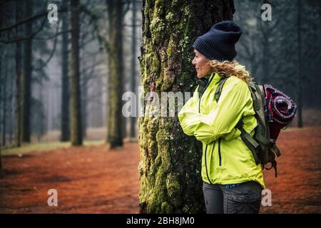 Femme solitaire de l'âge moyen caucasien debout dans la forêt et regarder le beau bois autour d'elle - concept de trekking alternative vacances en plein air sauvage - routard et voyageurs Banque D'Images