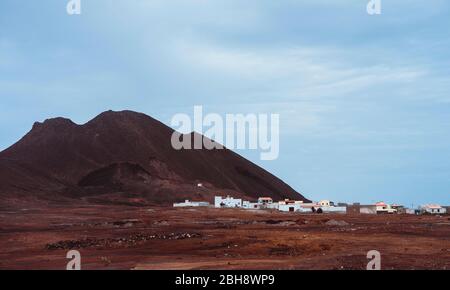 Village local Calhau au pied du cratère volcanique. Une seule martienne comme la roche rouge sèche se démarquent de la terre désertique stérile. Cap-Vert - Ile de Sao Vicente. Banque D'Images