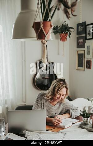 Frau mit Laptop und Notizbuch Banque D'Images