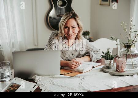 Frau mit Laptop und Notizbuch Banque D'Images