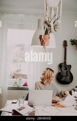 Frau mit Laptop und Notizbuch Banque D'Images