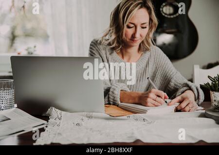 Frau mit Laptop und Notizbuch Banque D'Images