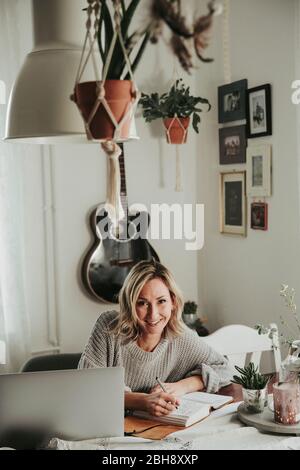 Frau mit Laptop und Notizbuch Banque D'Images