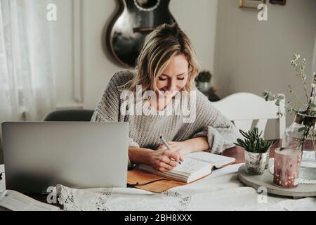 Frau mit Laptop und Notizbuch Banque D'Images