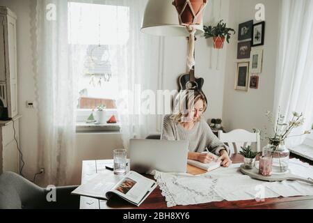 Frau mit Laptop und Notizbuch Banque D'Images