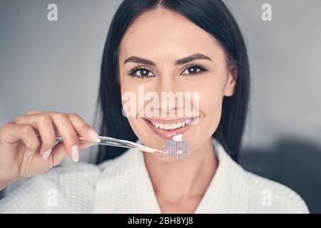 Jolie femme tenant une brosse à dents dans sa main Banque D'Images