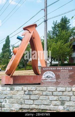 La sculpture de Fritz Church, la "Gateway", est la grande roue orange sur South Tacoma Way à Tacoma, Washington. Il repose sur deux pointes stylisées de chemin de fer. Banque D'Images