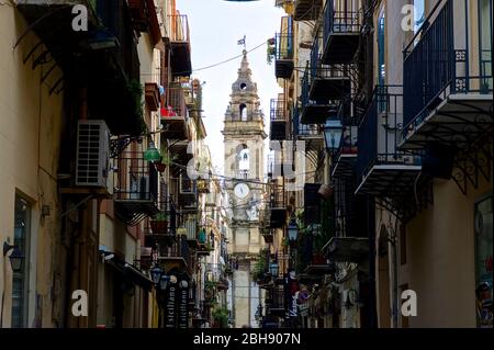 Palerme, vieille ville, vue par une rue étroite avec balcons sur une tour d'église Banque D'Images