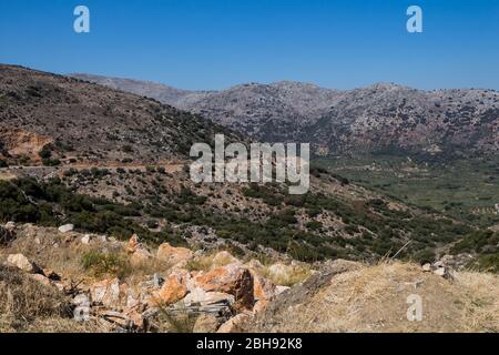 Montagnes Rocheuses et vallées avec oliviers et végétation variée. Journée ensoleillée avec ciel bleu en automne. Centre de la Crète, Grèce. Banque D'Images