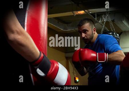 Vue latérale du boxeur homme confiant qui fait de l'exercice dans la salle de sport Banque D'Images