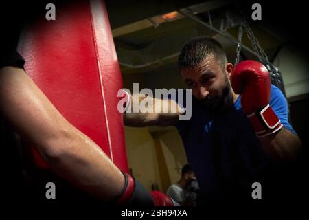 Vue latérale du boxeur homme confiant qui fait de l'exercice dans la salle de sport Banque D'Images