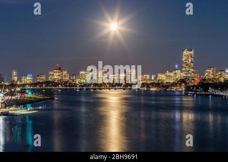 Pleine lune brillant au-dessus de la ville pendant l'heure bleue. Banque D'Images