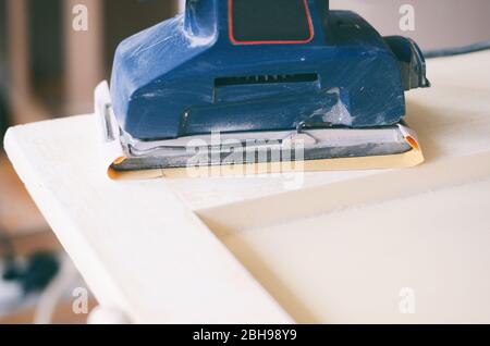 Le ponçage et la préparation des vieilles portes avec peinture craquelée pour une nouvelle couche de peinture lisse, ponçage ou décapage de concept. Banque D'Images