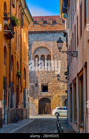 Ancienne rue dans le centre historique de Mantua (Lombardie, Italie) avec le Palazzo della Ragione médiéval en arrière-plan. Banque D'Images