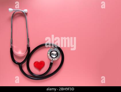 Journée infirmière internationale, concept de semaine, stéthoscope et coeur rouge sur fond rose avec espace de copie. Espace pour le texte. Banque D'Images