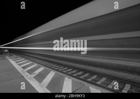 Longue exposition de trains en train dans la nuit dans une gare Banque D'Images