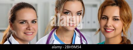 Trois médecins souriants en médecine féminine au bureau regardant en portrait de caméra Banque D'Images