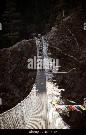 Randonnée à dos d'âne sur les drapeaux de prière du pont suspendu Banque D'Images