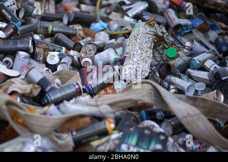 Les aérosols vides de pulvérisateurs graffiti négligemment sont empilés les uns sur les autres. Banque D'Images