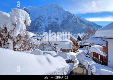 Maisons enneigées contre les montagnes de Karwendel, Mittenwald, Werdenfelser Land, Haute-Bavière, Bavière, Allemagne Banque D'Images