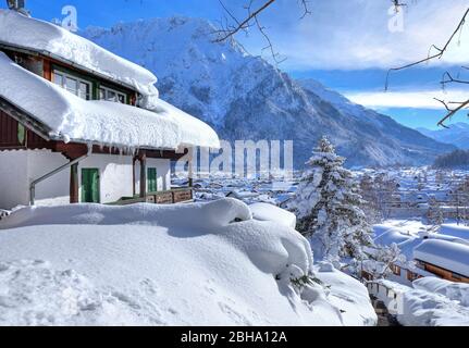 Maisons enneigées contre les montagnes de Karwendel, Mittenwald, Werdenfelser Land, Haute-Bavière, Bavière, Allemagne Banque D'Images