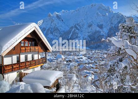 Maisons enneigées contre les montagnes de Karwendel, Mittenwald, Werdenfelser Land, Haute-Bavière, Bavière, Allemagne Banque D'Images