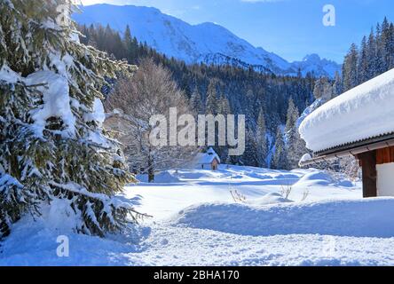 Maisons de neige profonde contre les montagnes de Wetterstein, à Elmau, près de Klais, Werdenfelser Land, Haute-Bavière, Bavière, Allemagne Banque D'Images