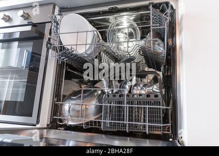 Ouvrez le lave-vaisselle avec des plats propres dans une cuisine blanche Banque D'Images
