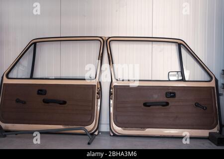 deux portes démontées d'un ancien stand de voiture sur un mur dans un atelier Banque D'Images