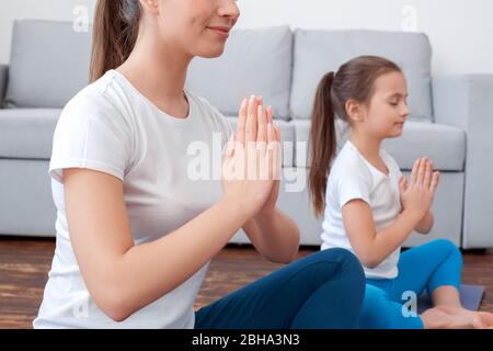 Jeune femme adulte et sa petite fille faisant du yoga ensemble à la maison Banque D'Images