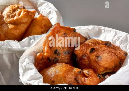 La nourriture hollandaise typique communément appelée beignets hollandais, dutchies ou oliebollen dans des sacs de papier blanc. Avec et sans raisins de Corinthe. Traditionnellement mangé sur ne Banque D'Images