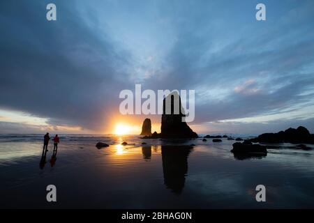 Silhouettes de formations rocheuses au coucher du soleil à Cannon Beach, Oregon, États-Unis Banque D'Images