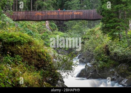 L'Europe, l'Autriche, le Tyrol, Neustift dans la vallée de Stubai, mère et fils sont debout sur un pont en bois et regardent vers le bas sur le Ruetz Banque D'Images