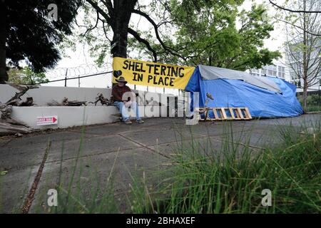 Portland, États-Unis. 24 avril 2020. Jeff Liddicoat est assis devant le camping qu'il appelle à la maison sur East Burnside Street à Portland, Oregon, le 24 avril 2020. Jeff, qui vit dans les rues de la région depuis près de 8 ans maintenant, a une station de lavage des mains à l'extérieur de sa tente pour que la communauté utilise grâce au groupe local de plaidoyer Stop the Sweeps PDX. (Photo d'Alex Milan Tracy/Sipa USA) crédit: SIPA USA/Alay Live News Banque D'Images