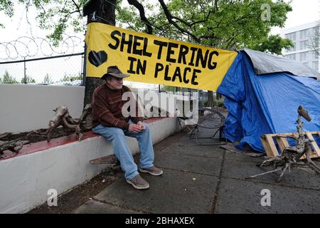 Portland, États-Unis. 24 avril 2020. Jeff Liddicoat est assis devant le camping qu'il appelle à la maison sur East Burnside Street à Portland, Oregon, le 24 avril 2020. Jeff, qui vit dans les rues de la région depuis près de 8 ans maintenant, a une station de lavage des mains à l'extérieur de sa tente pour que la communauté utilise grâce au groupe local de plaidoyer Stop the Sweeps PDX. (Photo d'Alex Milan Tracy/Sipa USA) crédit: SIPA USA/Alay Live News Banque D'Images