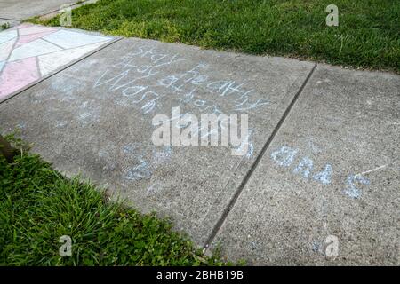 Les messages des enfants écrits dans un craie de trottoir rappelant aux gens de se laver les mains pendant la pandémie de Covid-19. Banque D'Images