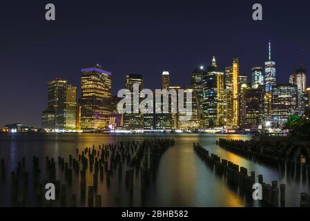 Vue sur l'Eastriver sur la silhouette du centre-ville de Manhattan comme une longue exposition la nuit Banque D'Images