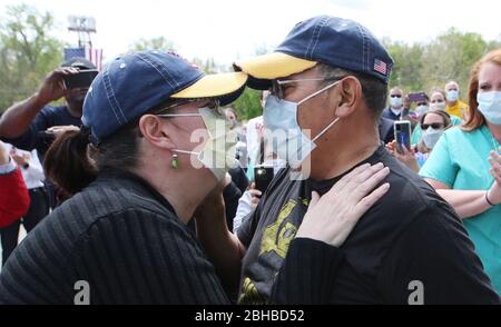 Chesterfield, États-Unis. 24 avril 2020. Le policier de la moto métropolitaine de Saint-Louis, Dave Tenorio, est accueilli pour la première fois par sa femme émotionnelle Kathy, lors d'une célébration de la décharge, à l'hôpital Saint-Luke, à Chesterfield, Missouri, le vendredi 24 avril 2020. Après avoir été admis le 1er avril, Tenorio est le premier patient de Saint Luke à être traité avec ECMO (oxygénation extracorporelle de membrane) et est le premier connu dans la région de Saint-Louis à être traité avec ECMO et à être libéré. Crédit: UPI/Alay Live News Banque D'Images