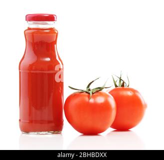 Bouteille de jus frais et sain avec tomates isolées sur blanc Banque D'Images