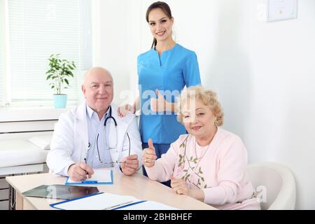 Médecins et patients heureux dans la clinique d'hôpital Banque D'Images