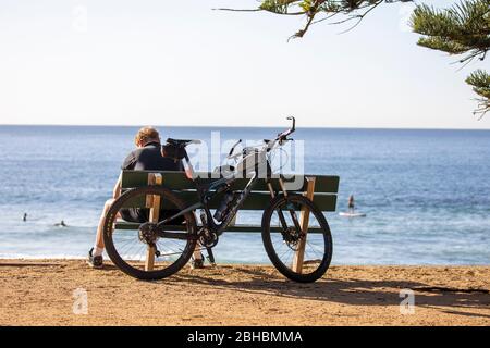 L'homme australien prend un repos en faisant du vélo de montagne scott à bord d'une plage de Sydney, en Nouvelle-Galles du Sud, en Australie Banque D'Images