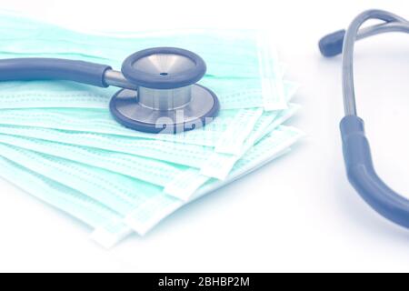 Stéthoscope sur masque chirurgical jetable sur fond blanc en ton bue avec espace de copie au fond de la toile. Banque D'Images